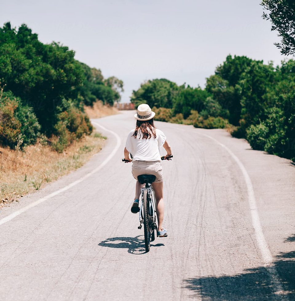 A tourist rides a bike up the road on Rottnest Island