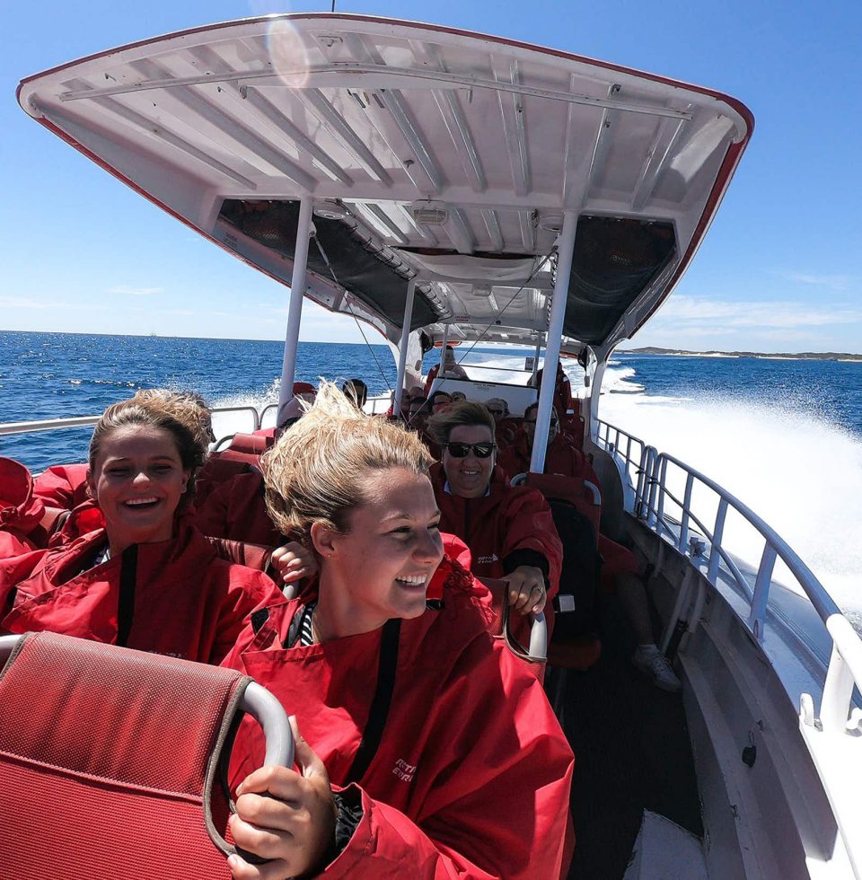 Tourists on the Rottnest Eco Express speed boat hang on tight while the boat moves fast along the water