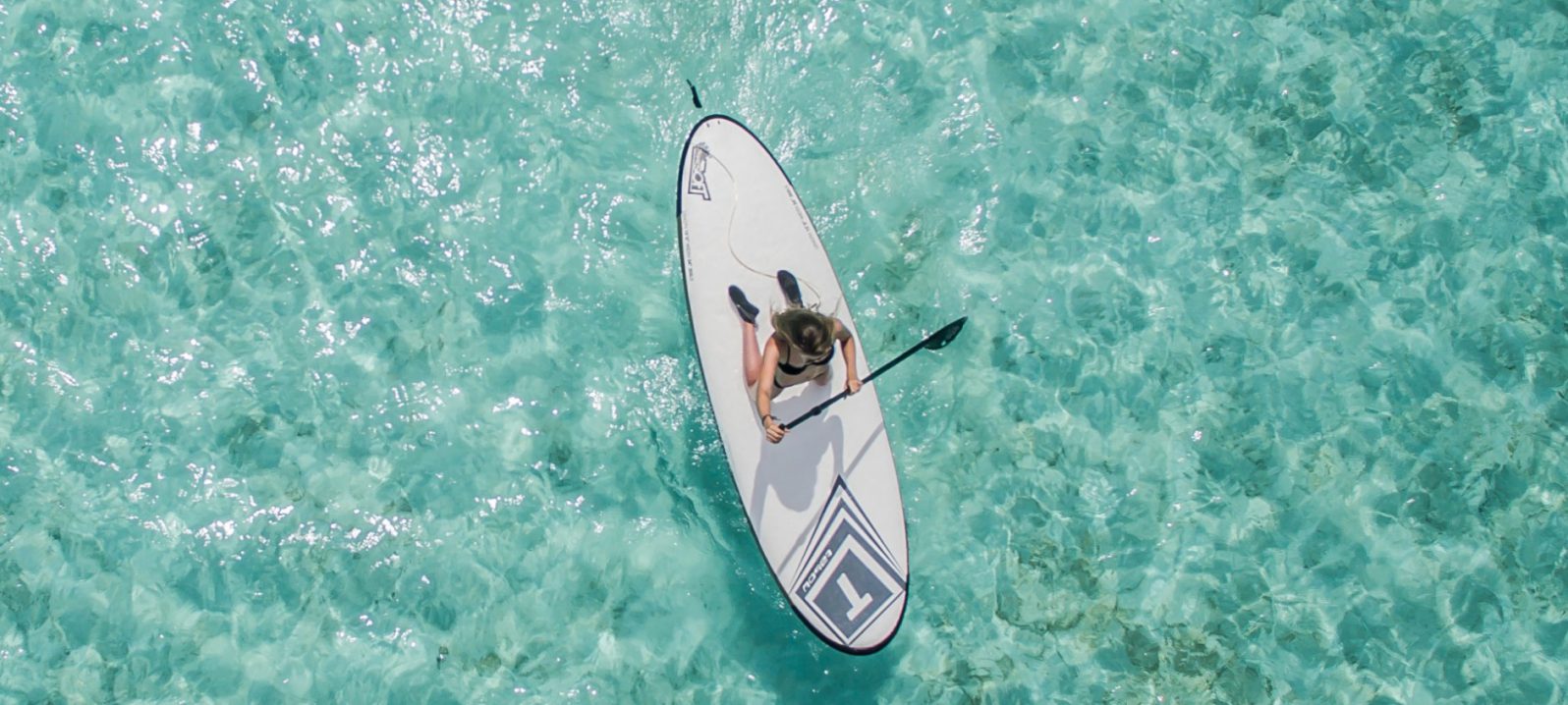 A tourist goes paddle boarding on the water in Rottnest Island