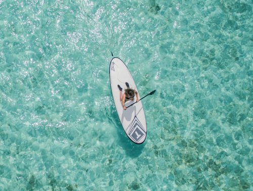 A tourist goes paddle boarding on the water in Rottnest Island