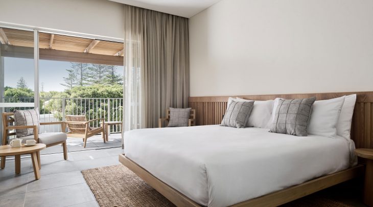 A queen size bed made with white sheets in the Beach Lane room at Samphire Rottnest hotel