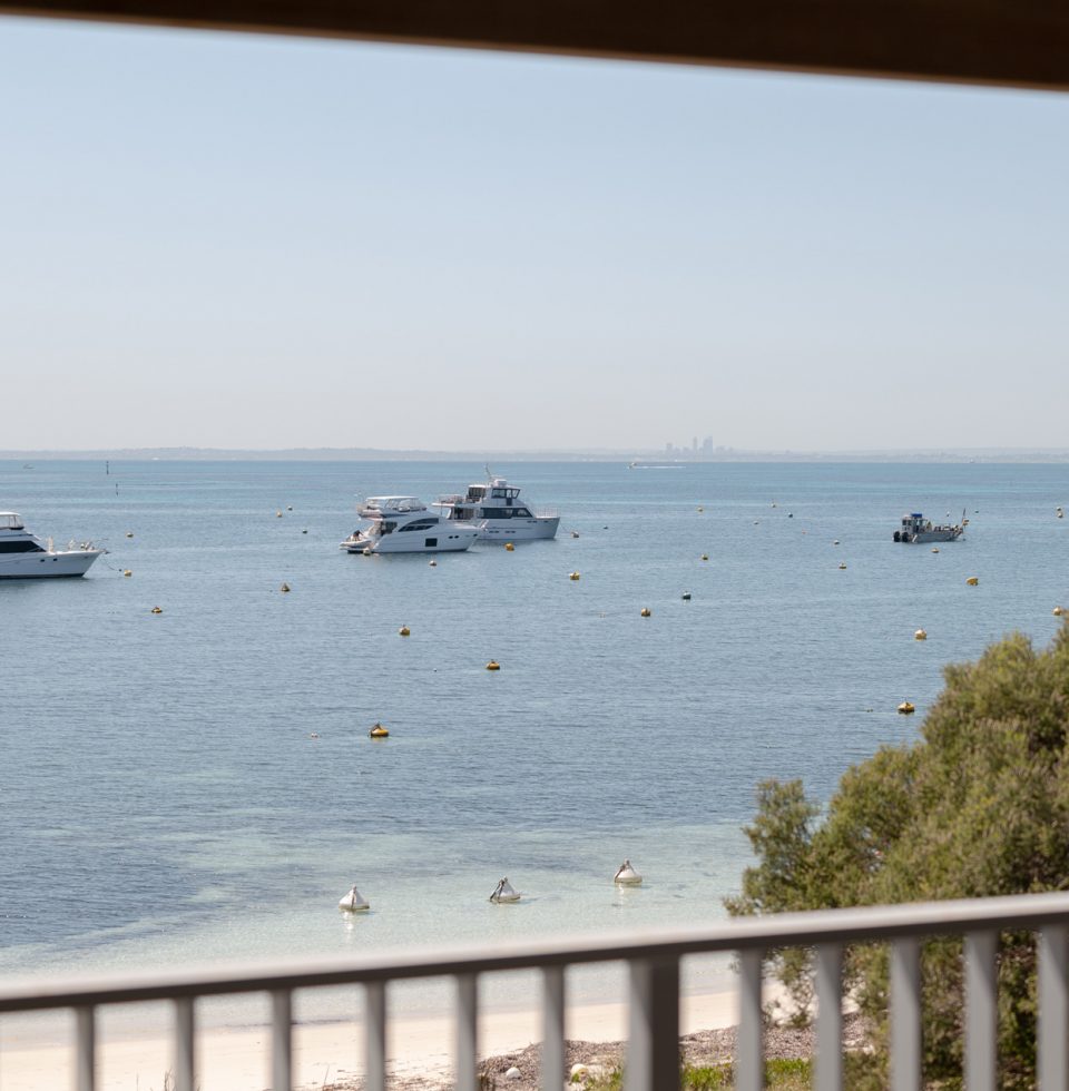 Boats idle in the water close to the shore on Rottnest Island