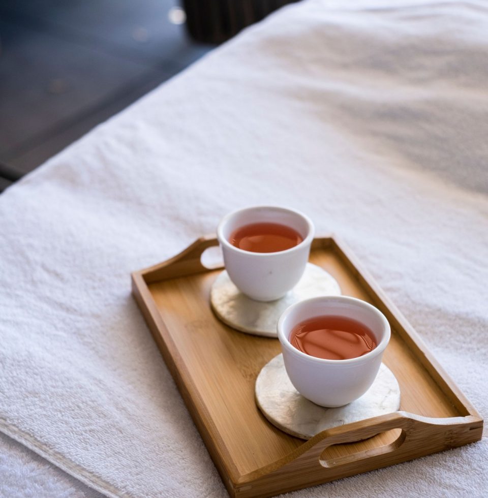 Two cups of tea on a tray are offered to hotel guests following a massage session
