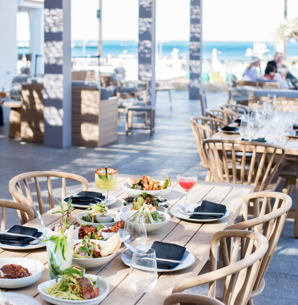 Tables are laid with various Asian-inspired dishes and cocktails