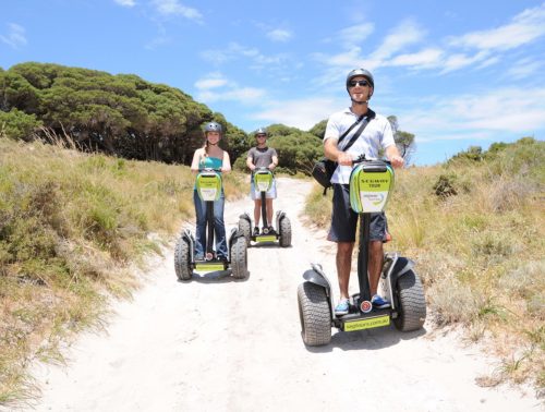 Three tourists ride on a segway tour through the bushland on Rottnest Island