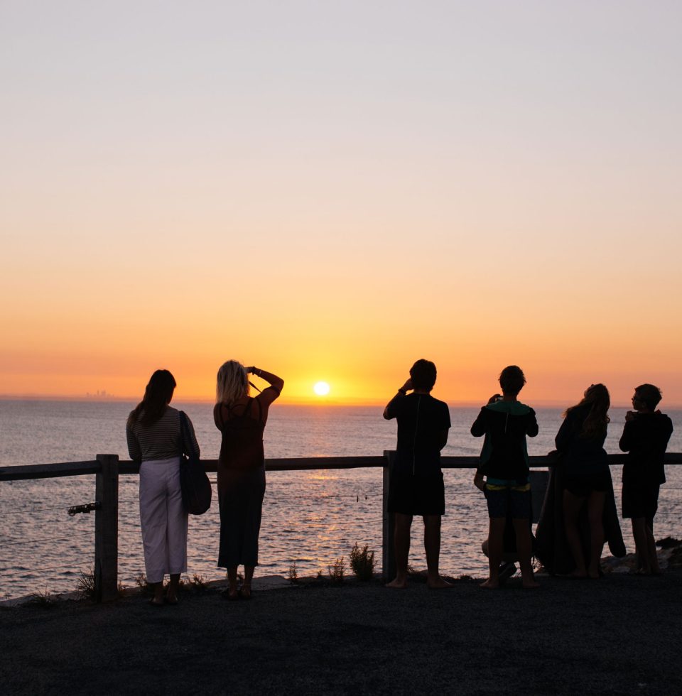 A group of tourists taking photos of a beautiful sunset on Rottnest Island