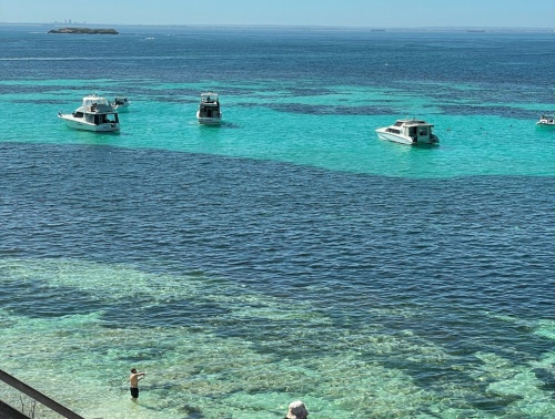 Stairs leading to the azure waters of Parker Point with yachts in the background